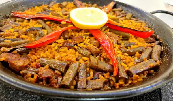 Paella mit Schweinefleisch und frischen Ackerbohnen