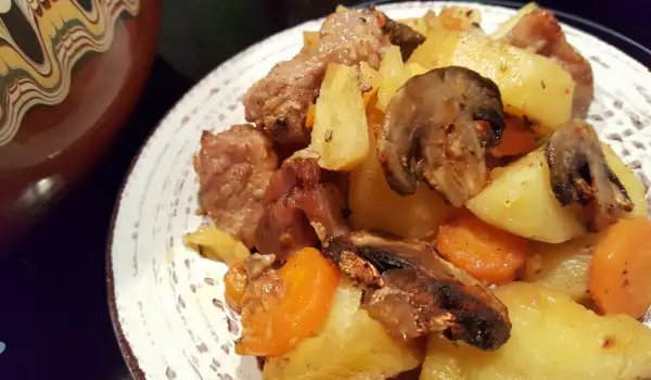 Schweinefleisch mit roten Kartoffeln und Pilzen im Güvec