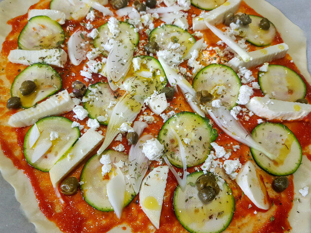 Dünne Pizza mit Mozzarella, Ricotta und Zucchini
